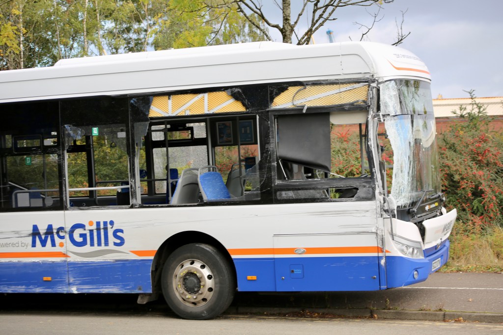 Damaged McGill's bus parked on the side of a road, showing broken windows and visible wear.